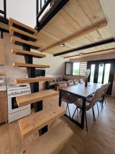 a kitchen and dining room with a table and a spiral staircase at Vikendica Vukasin in Zasavica Prva