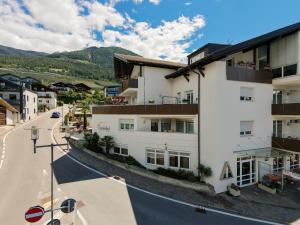 an apartment building in a town with a street at Hotel Tannerhof in Schenna