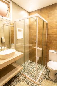 a bathroom with a glass shower and a toilet at Hotel Rio Guarujá - "Sua casa na praia" in Guarujá