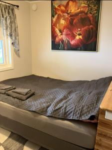 a bed in a room with a painting on the wall at Ferieleilighet Kragerø in Kragerø