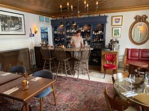 a man standing at a bar in a restaurant at Windsor House Inn in Saint Andrews