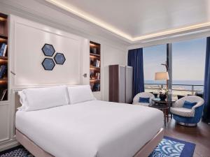 a bedroom with a white bed and a large window at Sofitel Barcelona Skipper in Barcelona +222 photos