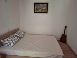 a small bedroom with a bed and a guitar at EmiliJana House in Dolna Matka