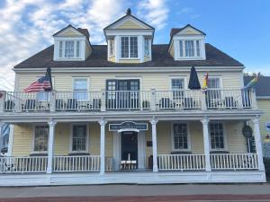 a white house with a balcony and an american flag at Windsor House Inn in Saint Andrews +23 photos