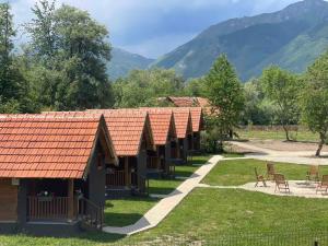a group of cottages with mountains in the background at ABBA Ethno House in Gusinje