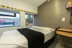 a small bedroom with a bed and a window at Hotel Zona Express San Diego in Medellín +22 photos
