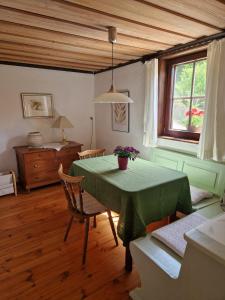 a dining room with a green table and chairs at Charme im Fachwerkhaus in Sugenheim