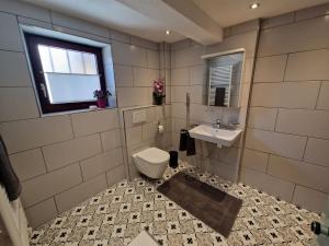 a bathroom with a toilet and a sink and a window at Charme im Fachwerkhaus in Sugenheim +13 photos