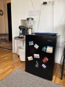 a black refrigerator with magnets on it in a room at Central Artsy Studio, self check-in! in Bucharest