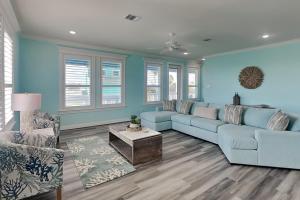 a blue living room with a blue couch and chairs at Tortuga Moon in Galveston