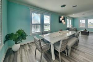 a dining room with a white table and chairs at Tortuga Moon in Galveston