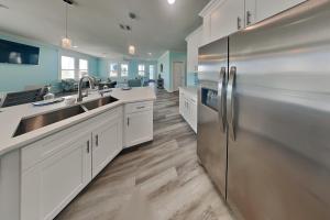 a kitchen with white cabinets and stainless steel appliances at Tortuga Moon in Galveston