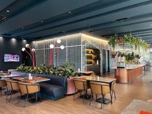 a restaurant with tables and chairs and plants at ibis Medellin in Medellín