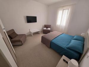 a bedroom with a bed and a chair and a television at Piccola Chappy in Taranto