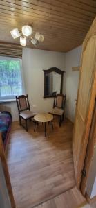a living room with two chairs and a table at Sodyba pas Babą - namas KLASIKA in Palanga