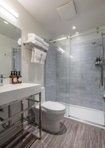 a bathroom with a shower and a toilet and a sink at Duffin Cove Resort in Tofino +42 photos