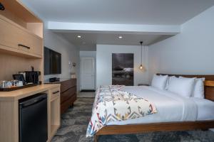 a hotel room with a bed and a kitchen at Duffin Cove Resort in Tofino