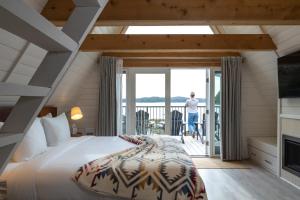 a bedroom with a large bed and a balcony at Duffin Cove Resort in Tofino