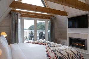 a bedroom with a bed and a fireplace at Duffin Cove Resort in Tofino