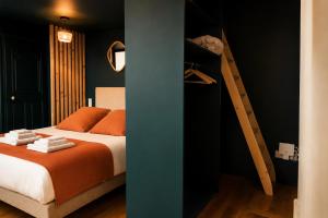 a bedroom with a bed with orange pillows and a ladder at La Parenthèse Fléchoise, Chambre Raphaël in La Flèche +123 photos