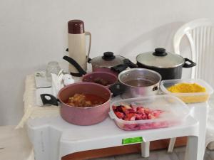 a table with pots and pans of food on a table at Pousada Mais E Vida 24h in Teresina