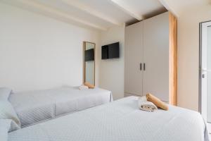 a bedroom with two beds and a tv on the wall at Elcano Living 6 in Grao de Castellón