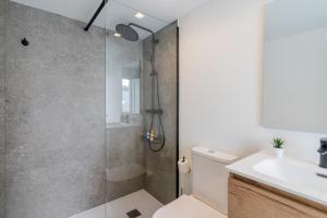 a bathroom with a shower and a toilet and a sink at Elcano Living 6 in Grao de Castellón +52 photos