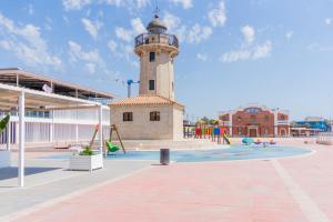 a building with a clock tower in a playground at Elcano Living 6 in Grao de Castellón