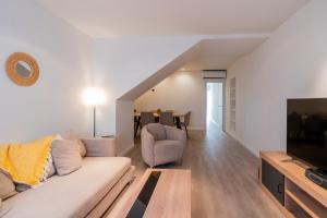 a living room with a couch and a television at Elcano Living 6 in Grao de Castellón