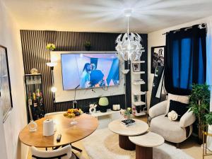 a living room with a tv and a table at Val hôtel in Courcouronnes