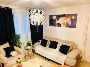 a living room with two couches and a chandelier at Val hôtel in Courcouronnes
