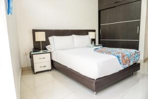 a bedroom with a large bed and two night stands at Hotel Bolivariana Plaza Medellin in Medellín