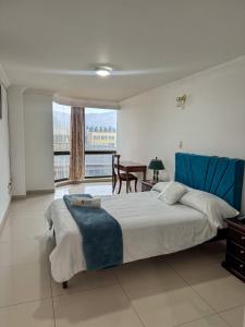 a bedroom with a bed and a table and a window at HOTEL REALPICO VICTORIA in Duitama