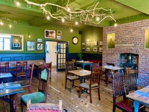a restaurant with tables and chairs and a fireplace at The Teesdale Hotel in Middleton in Teesdale
