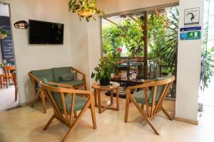 a room with chairs and a table and a television at Hotel Bolivariana Plaza Medellin in Medellín