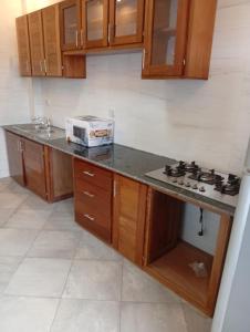 a kitchen with wooden cabinets and a stove top at Résidence Prestige KGV Appt 301 in Douala
