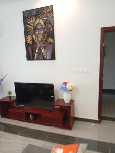 a living room with a television and a painting on the wall at Résidence Prestige KGV Appt 301 in Douala
