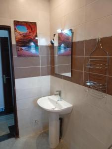 a bathroom with a sink and a mirror at Résidence Prestige KGV Appt 301 in Douala