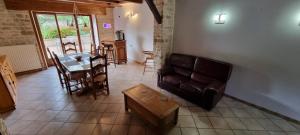a living room with a couch and a table at Le gîte des Sorbiers in Charmes-lès-Langres