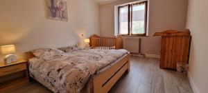 a bedroom with a large bed and a window at Le gîte des Sorbiers in Charmes-lès-Langres