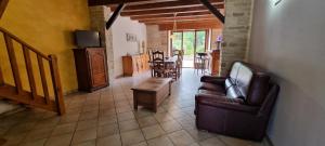 a living room with a couch and a table at Le gîte des Sorbiers in Charmes-lès-Langres