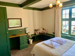 a bedroom with a bed and a desk and a window at The Teesdale Hotel in Middleton in Teesdale