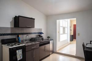 a kitchen with a stove and a sink and a door at Estudio #2 a 5 min del malecon in La Paz