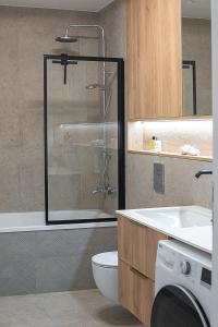 a bathroom with a shower and a toilet and a sink at V39 New Apartment in Vilnius +14 photos
