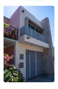a white house with a balcony and some flowers at Estudio #2 a 5 min del malecon in La Paz