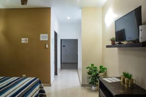 a room with a bed and a flat screen tv at Estudio #2 a 5 min del malecon in La Paz