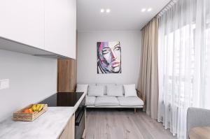 a living room with a couch and a painting on the wall at V39 New Apartment in Vilnius