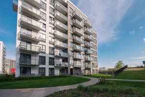 a large apartment building with a grassy area next to it at V39 New Apartment in Vilnius