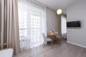 a living room with a table and a large window at V39 New Apartment in Vilnius