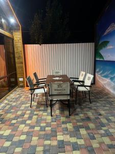 a table and chairs on a patio with a wall at Green Village in Balqash +3 photos